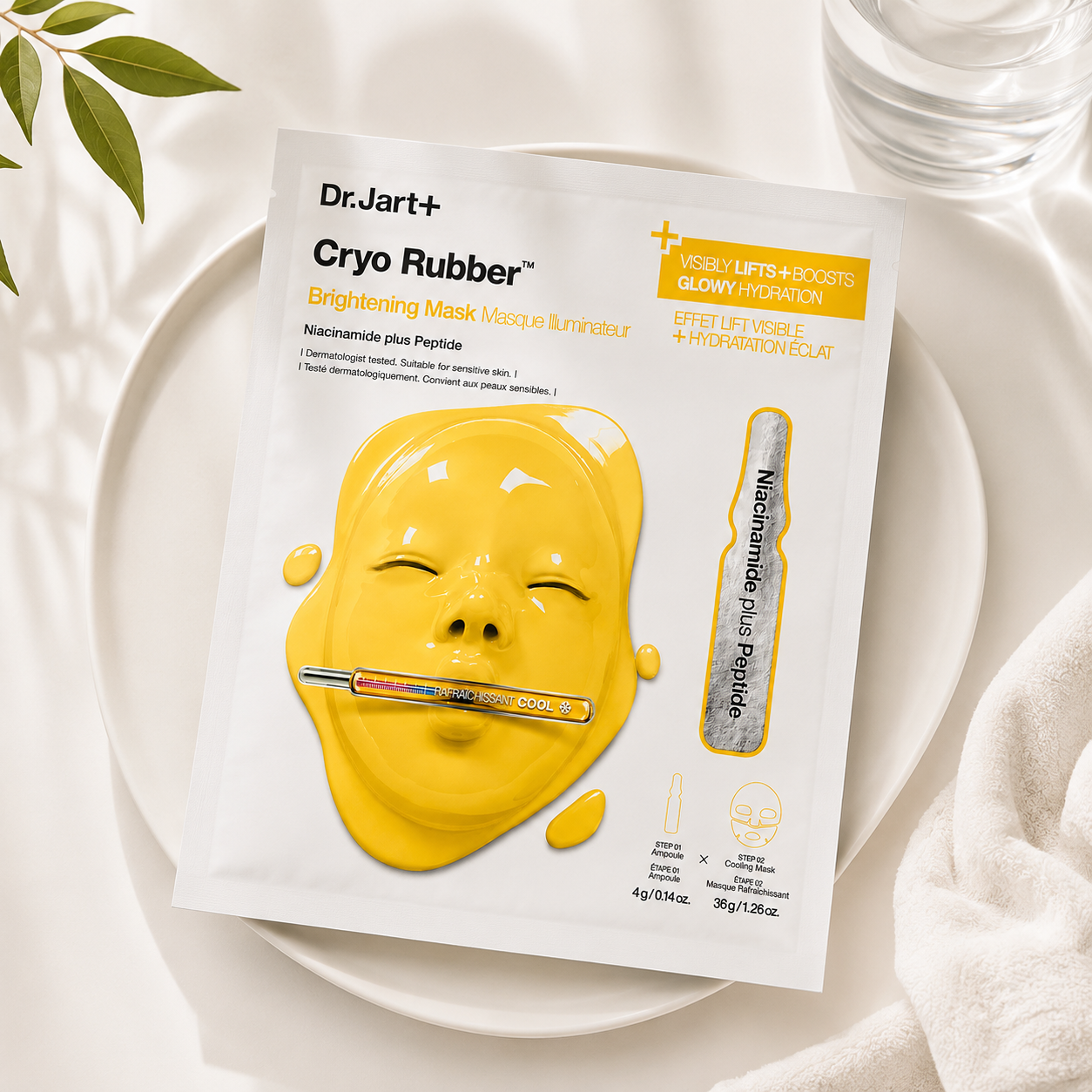 Dr.Jart+ Cryo Rubber Brightening Mask with Niacinamide Plus Peptide sachet elegantly displayed on a minimalist ceramic tray surrounded by soft natural light, fresh greenery, crystal-clear glassware and plush white towels, creating a premium spa-inspired setting that emphasizes skin brightening, radiant hydration and a refreshing Korean skincare ritual.